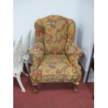 An XVIII Century Style Wing Chair, on cabriole legs, claw and ball feet, upholstered in brown floral