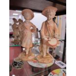 A Pair of Royal Worcester Porcelain Figures, in the Kate Greenway style, in blush ivory glaze,