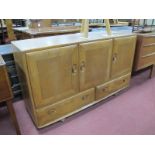Ercol Sideboard, with oval handles to three cupboard doors, over twin drawers 129.5cm, wide.