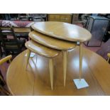 Ercol Nest of Three Blonde Pebble Top Coffee Tables, on splayed legs, the largest 65cm wide.