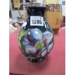 Moorcroft Pottery Vase, painted in the 'Clematis' pattern on deep blue ground, 15cm high.