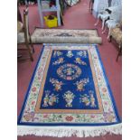 WITHDRAWN Chinese Wool Tasseled Rug, featuring vases of flowers and central wreath, on blue ground
