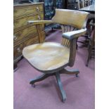 Early XX Century Oak Office Swivel Chair, with a low back, shaped arms, solid seat, on four shaped