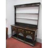 An XVIII Century Style Oak Dresser, the top with a stepped cornice to three open shelves with hooks,