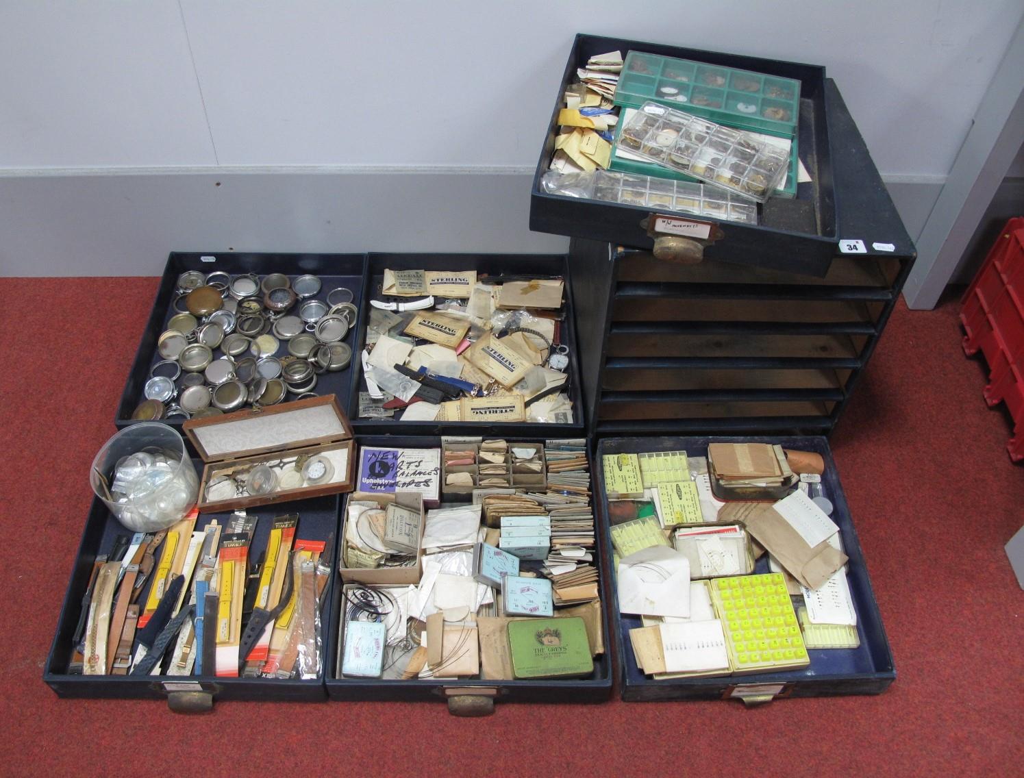 A Watchmaker's Table Top Chest of Drawers, containing pocket watch cases, hands, watch straps,