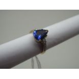 A Modern 18ct Gold Tanzanite and Diamond Set Ring, the large pear shape tanzanite claw set high