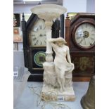 An Alabaster Figure of a Scantily Clad Maiden, circa 1900, stood beside a wall, as a table lamp,