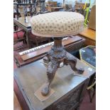 A XIX Century Walnut Stool, having poker work carving to tripod legs, circular fabric top, swivel