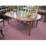 A Dalescraft Teak Extending Dining Table, with two spare leaves under top, on tubular legs,