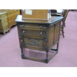 An Oak Side Table, with angular front, two drawers over cupboard door, knulled and carved