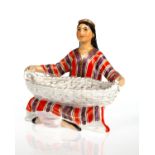 A SOVIET PORCELAIN OF 'AN UZBEK WOMAN WITH BASKET', LOMONOSOV STATE PORCELAIN FACTORY, LENINGRAD