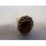 Garnet and diamond cluster ring - the central stone encased by 14 diamonds in unmarked gold