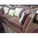 Knole sofa upholstered in a red and gold diamond pattern fabric with satin scatter cushions