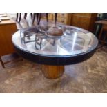 Dining table constructed from substantial iron rimmed cartwheel on tree trunk base,