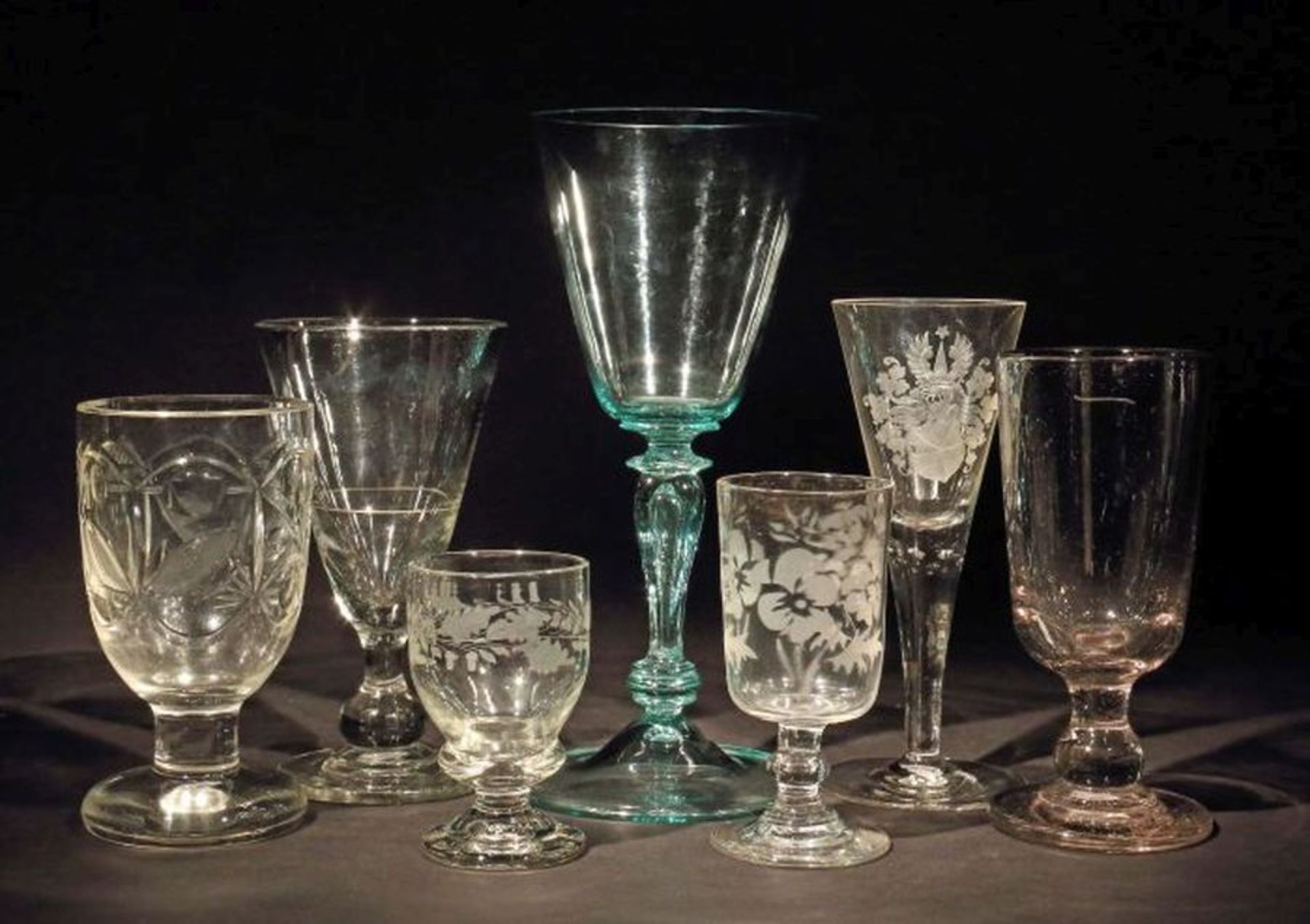 Sieben variierende Gläser 19./20. Jh., farbloses oder farbig schimmerndes Glas, tlw. geschliffen,