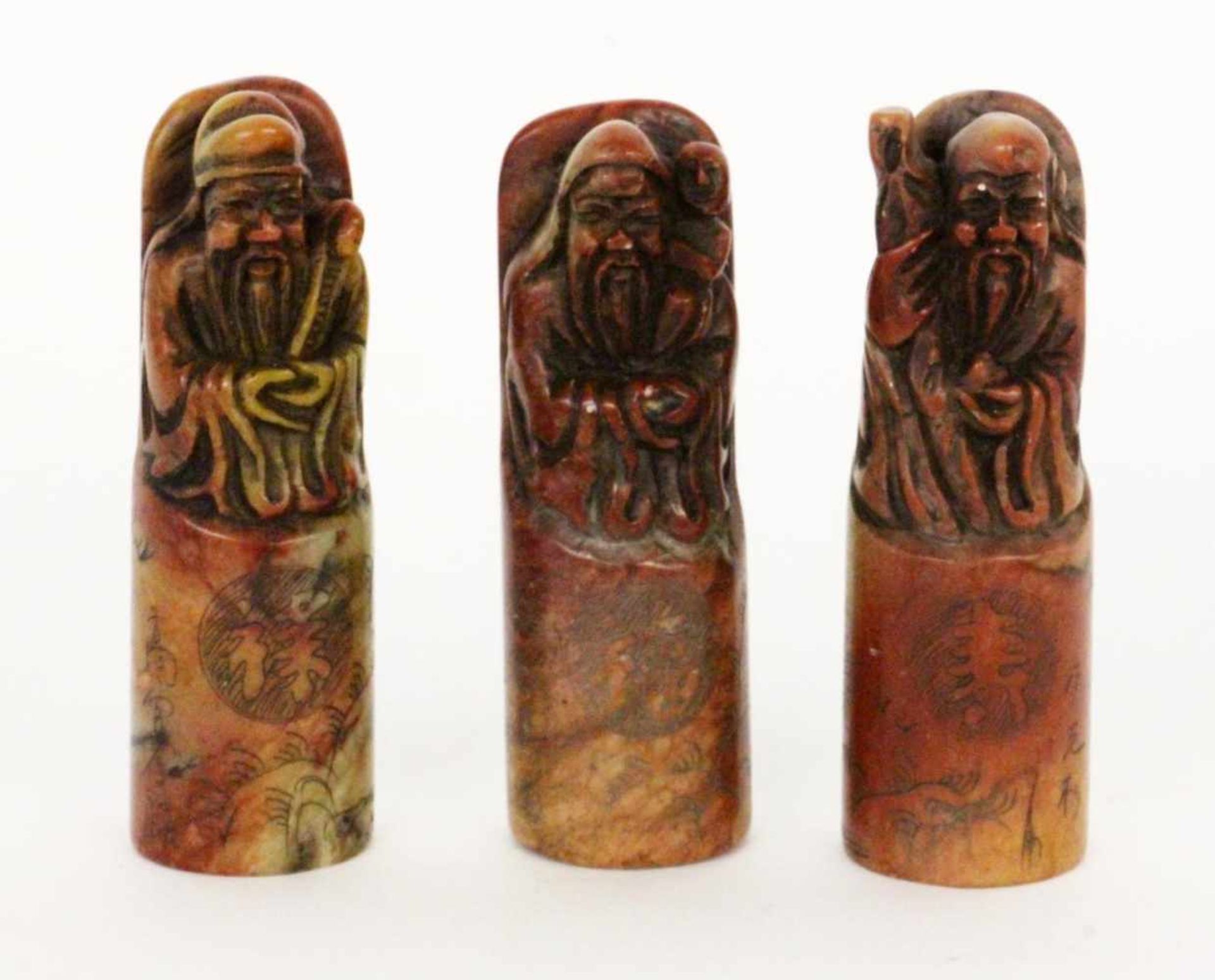 ''THREE FIGURES OF GODS China. Probably red marble. Cut figures and engraved decoration.