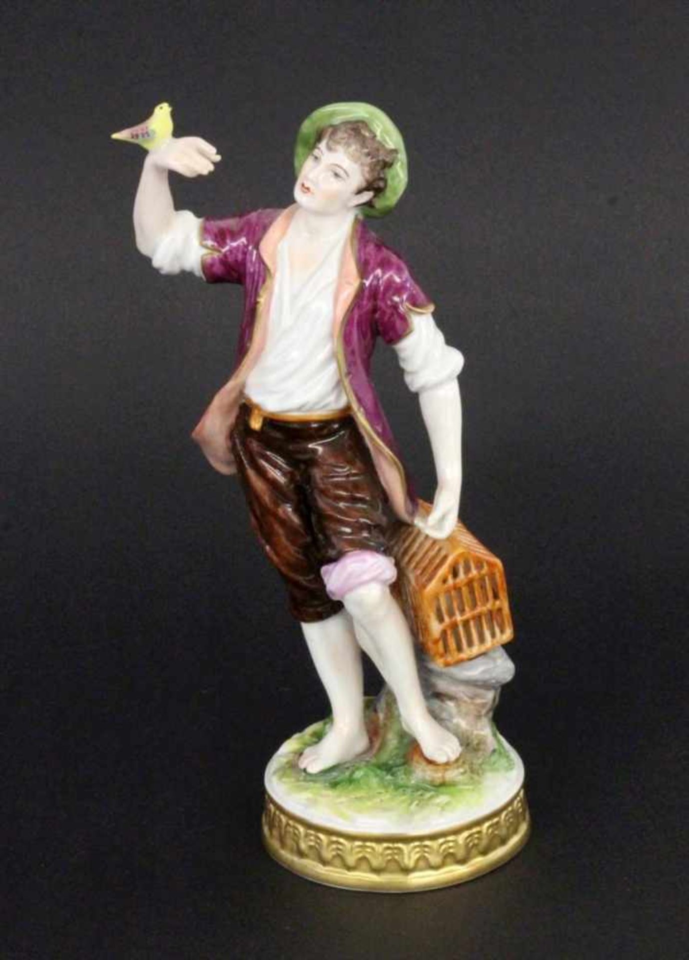 ''A MALE BIRD SELLER Volkstedt, Thuringia Colourfully decorated porcelain figure of a young