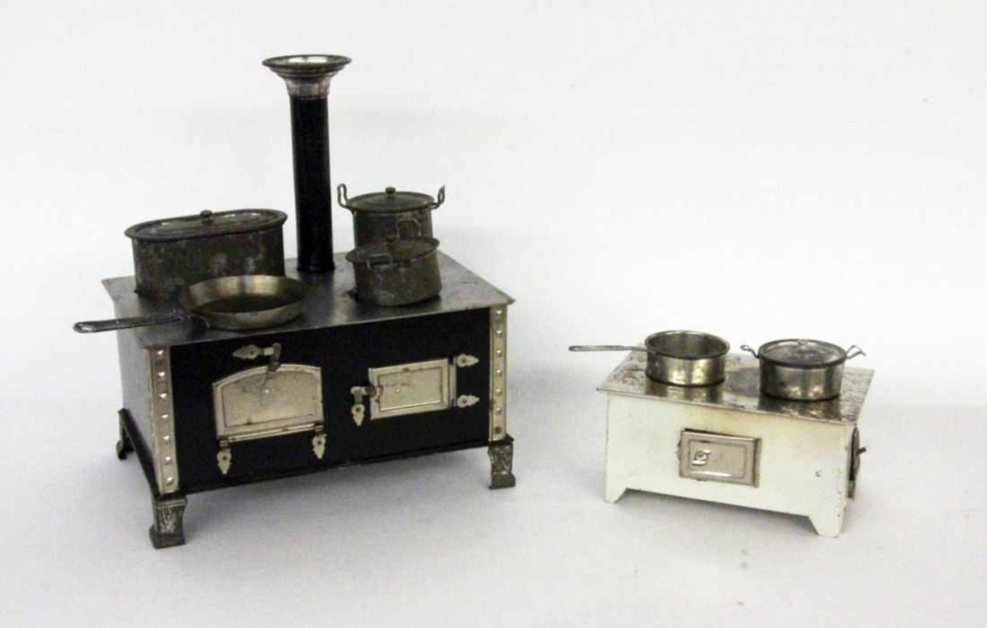 ''TWO OLD DOLL STOVES made of sheet metal. Pots included.Keywords: toys''