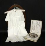 ''AN OLD CHRISTENING GOWN, white with lace trim. 65 cm long. Includes a silver-plated