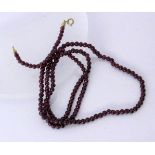 A NECKLACE WITH GARNET BEADS Diameter 4 mm, length 74 cm. Clasp gold-plated. Keywords: