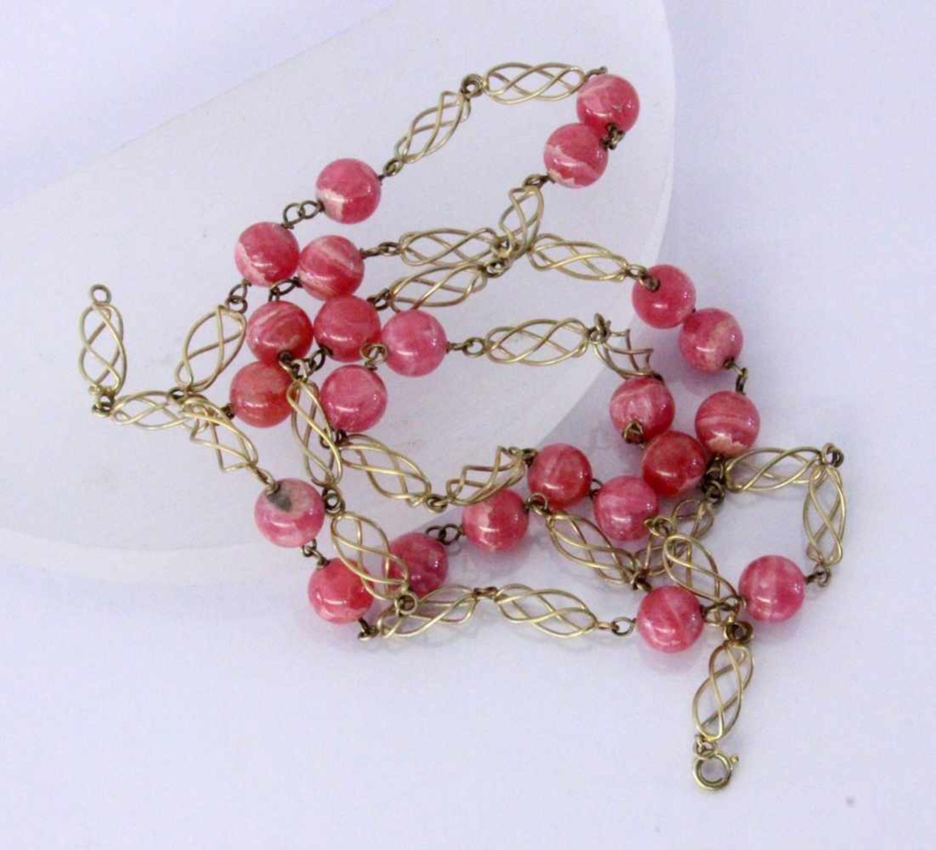 A NECKLACE WITH RHODOCHROSITE BEADS Silver, gold-plated. Diameter 9 mm, length 83.5 cm.