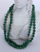 A NECKLACE WITH JADE BEADS Silver clasp. Diameter 7 mm, length 83 cm. Keywords: jewellery,