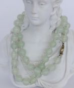 A NECKLACE WITH LIGHT JADE BEADS Silver clasp. Diameter 11 mm, length 61 cm. Keywords: