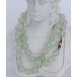 A NECKLACE WITH LIGHT JADE BEADS Silver clasp. Diameter 11 mm, length 61 cm. Keywords: