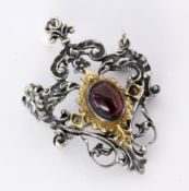 A COSTUME BROOCH Silver with a garnet cabochon and an attached pearl. 5 cm long, gross