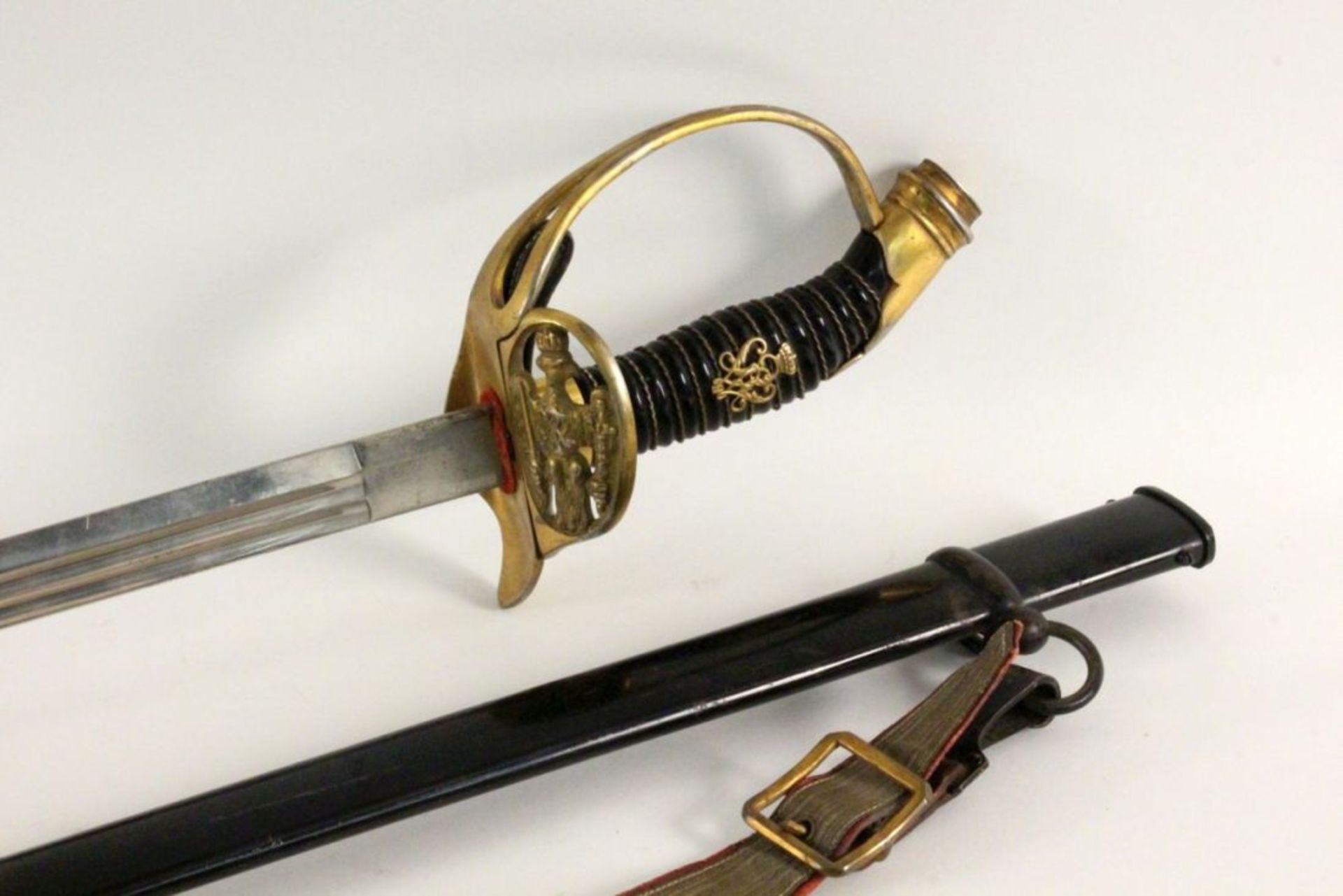 AN INFANTRY OFFICER’S SWORD Prussian circa 1900. Black iron scabbard. Brass hilt with Prussian