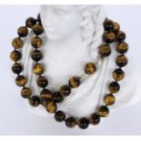 A NECKLACE WITH TIGER'S EYE BEADS Clasp 750/000 yellow gold. Diameter 12 mm, length 63.5