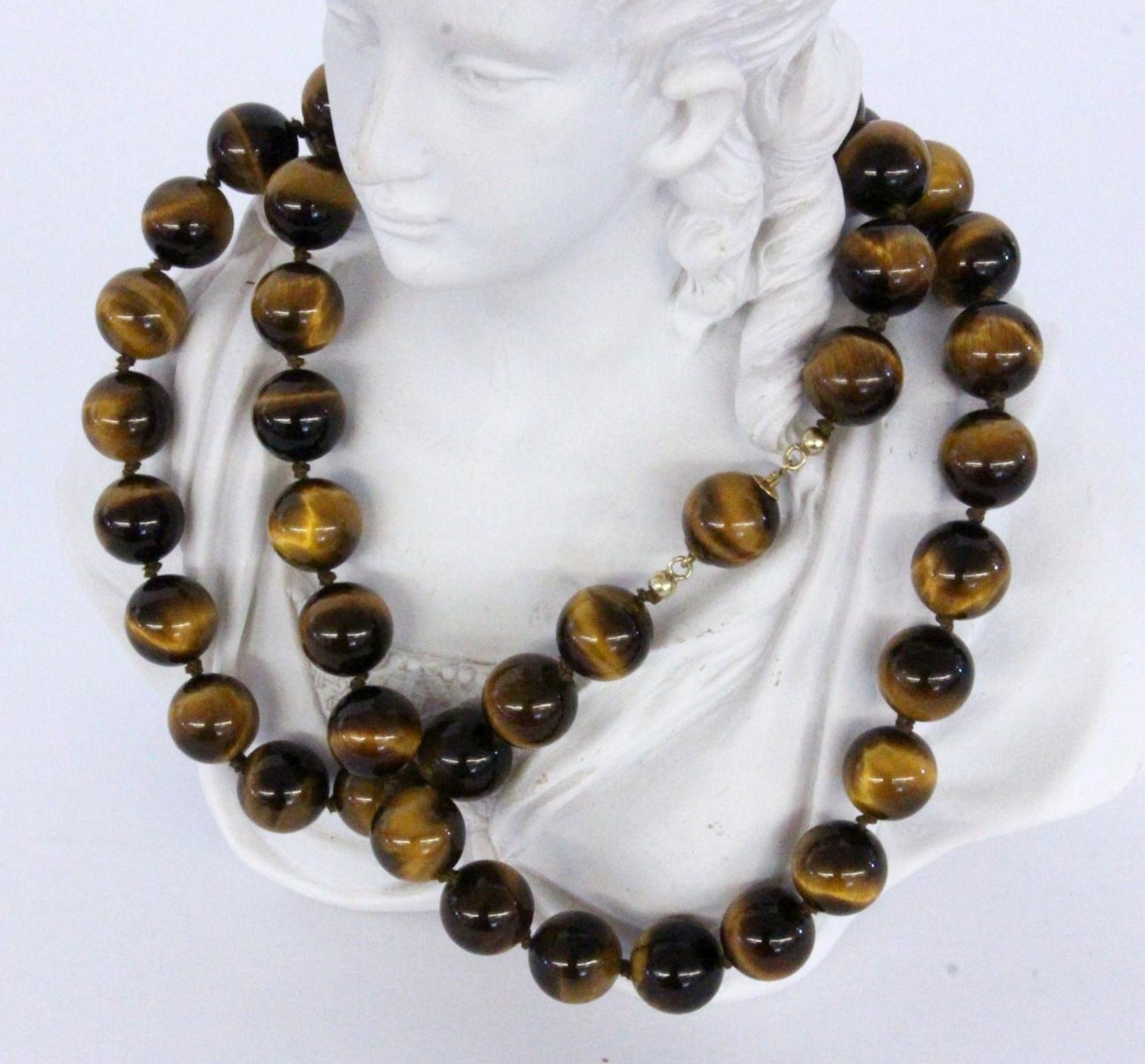 A NECKLACE WITH TIGER'S EYE BEADS Clasp 750/000 yellow gold. Diameter 12 mm, length 63.5