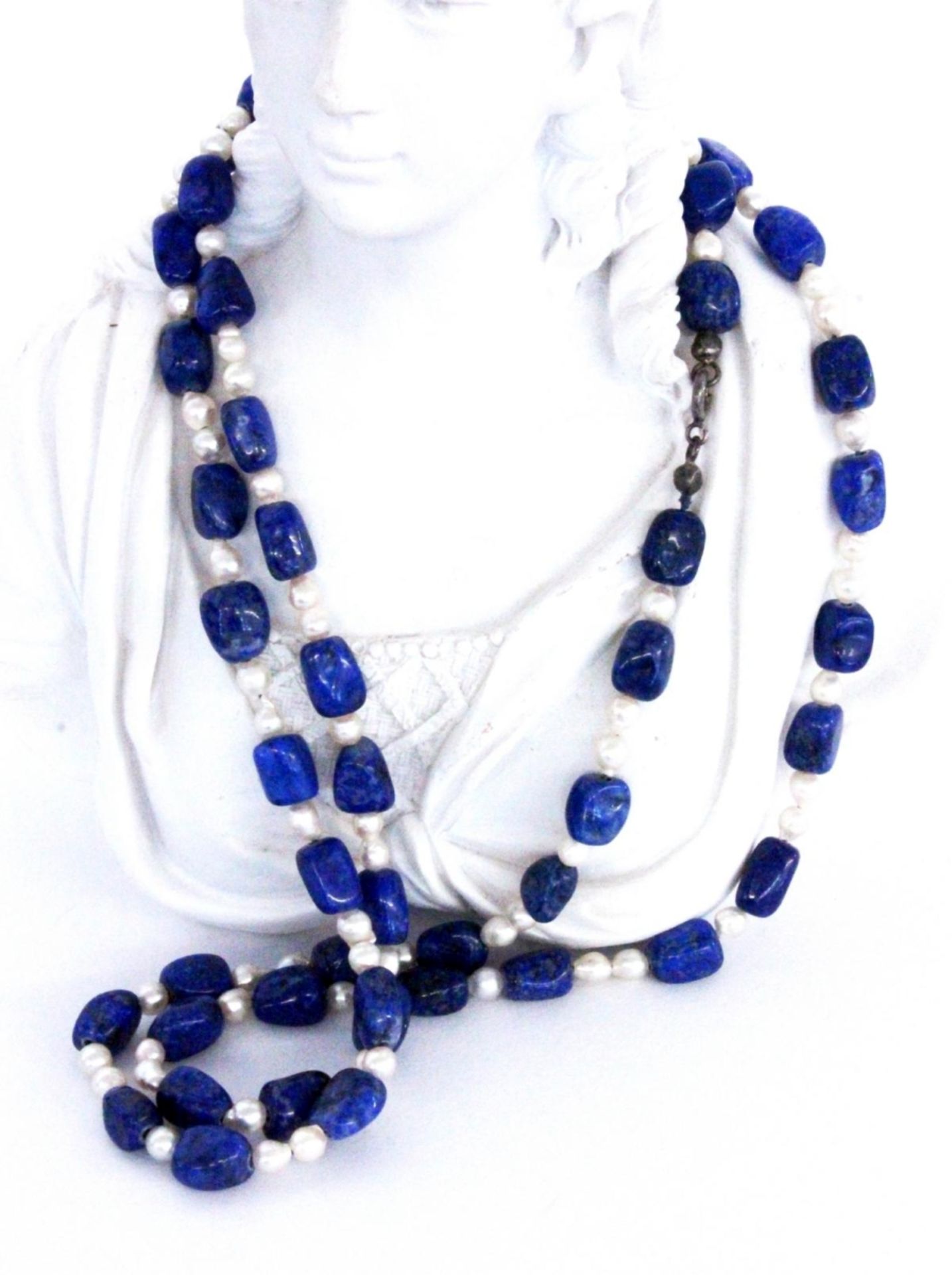 A NECKLACE with lapis lazuli nuggets and cultured pearls. 89 cm long, metal clasp.