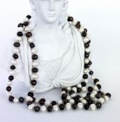A PEARL NECKLACE with white and black coloured baroque pearls. Endless, length 116 cm.