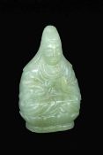 A GUANYIN JADE FIGURE China Carved jade goddess sitting on a lotus throne. She holds a