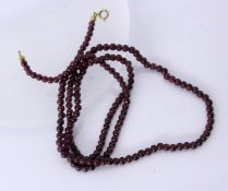 A NECKLACE WITH GARNET BEADS Diameter 4 mm, length 74 cm. Clasp gold-plated. Keywords: