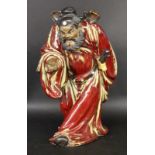 A SAMURAI Japan, 20th century Glazed ceramic figure of a Japanese warrior in a red coat.