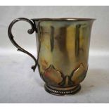A George V silver Footed Tankard, U shape with everted lip, S scroll handle, raised decoration