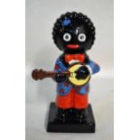A Carlton ware Colour Trial piece, modelled as a Black Boy Playing a Banjo in a blue jacket with red