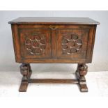 A Jacobean style oak Kist on Stand, hinged rectangular top above an asymmetric front board with a