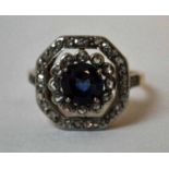 An Art Deco gold Dress Ring, octagonal target form, a central sapphire style stone in four claw