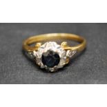 An 18ct gold diamond and sapphire Cluster Ring, six small diamonds in illusion settings around a