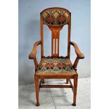 A good Arts and Crafts oak Carver Chair, arched back rail incorporating oval upholstered pad,