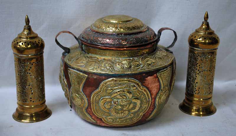 A Tibetan copper and brass two-handled covered vessel, heavily embossed with foliate design,