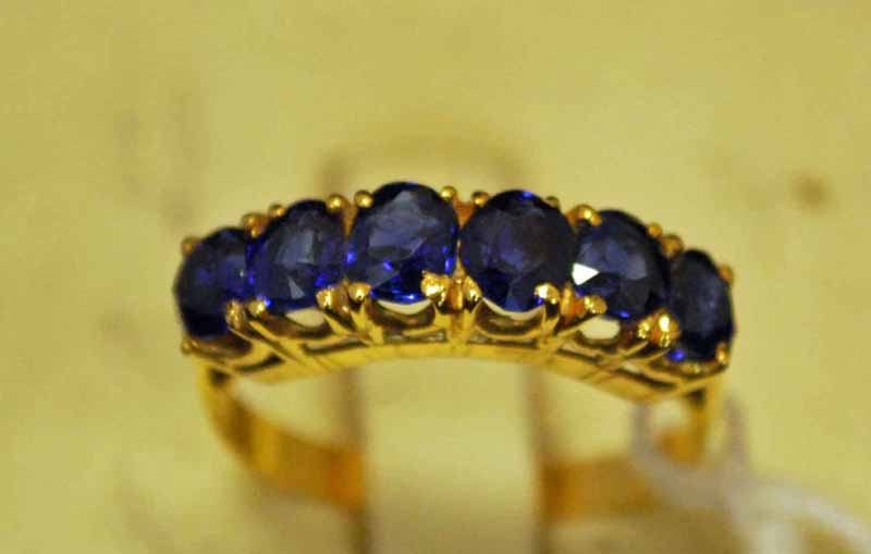 A Burmese sapphire six stone banded ring, tested as 18ct, size N