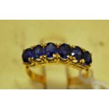 A Burmese sapphire six stone banded ring, tested as 18ct, size N