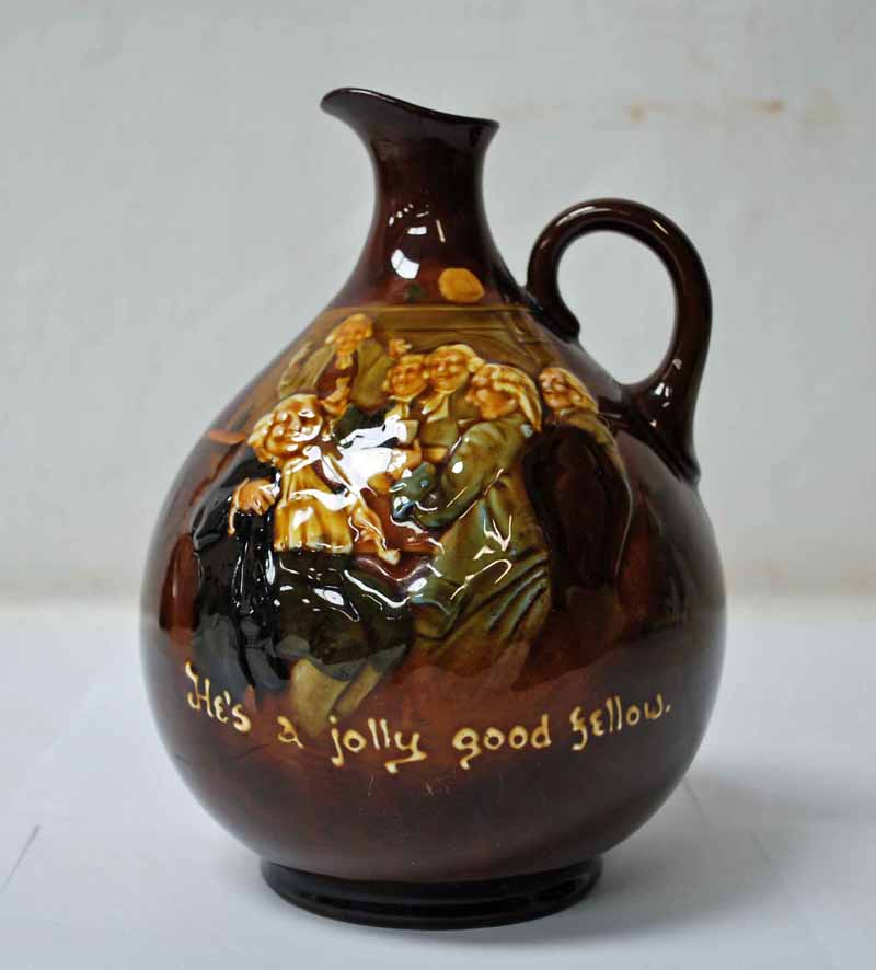 A Royal Doulton Kingswear Jug, this rich brown jug features Jolly Revellers singing 'He's a Jolly