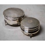 An early 20th century silver hinged lidded box of compressed circular form, three-footed, engine