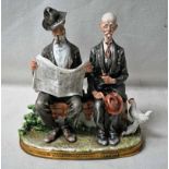 A Capodimonte porcelain figural group as two elderly gentlemen sitting on a bench, one reading a