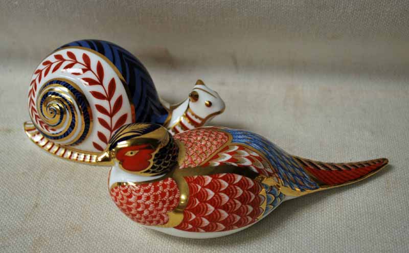 A Royal Crown Derby Desk Weight as a Pheasant, no stopper, 18cm long and another as a Snail, no